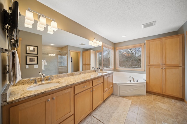 bathroom with a textured ceiling, vanity, shower with separate bathtub, and tile patterned floors