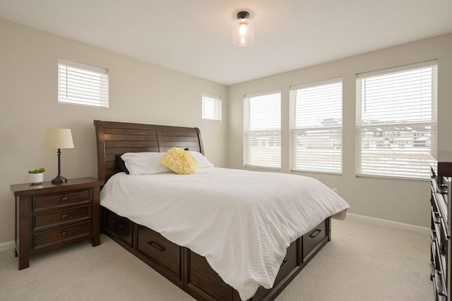 bedroom with multiple windows, baseboards, and light colored carpet