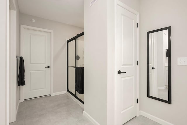 full bath with a stall shower and baseboards