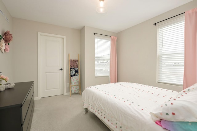 bedroom featuring multiple windows, baseboards, and light colored carpet