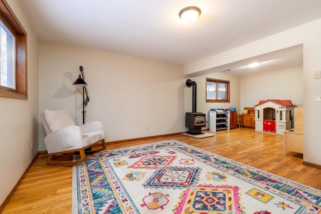 sitting room featuring a wood stove and hardwood / wood-style floors