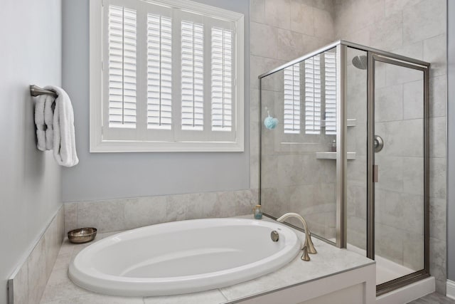 bathroom featuring a shower stall and a bath