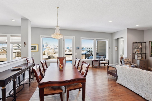 dining area featuring dark wood-style floors, a textured ceiling, and plenty of natural light