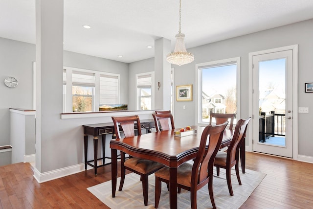 dining area with a wealth of natural light, baseboards, and wood finished floors