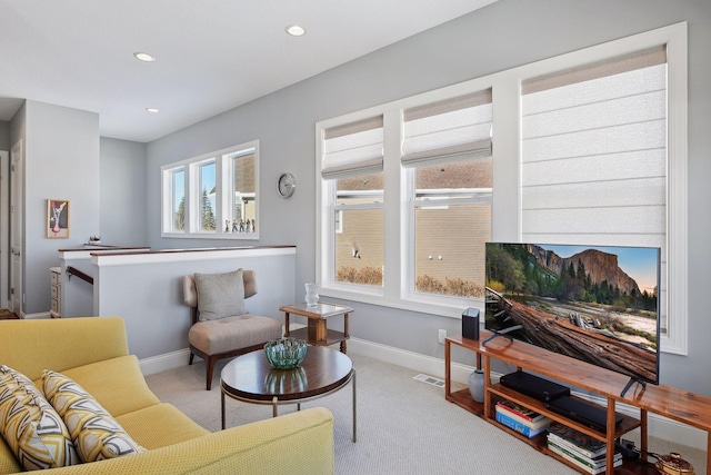 living area featuring light carpet, visible vents, baseboards, and recessed lighting