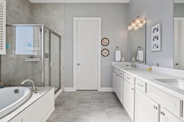 bathroom with double vanity, a shower stall, baseboards, and a sink