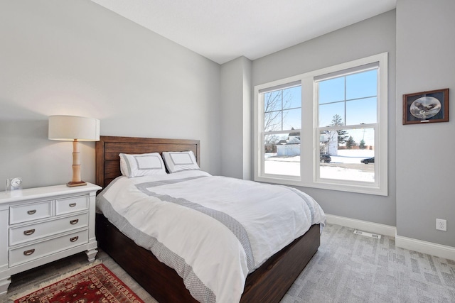 bedroom with light colored carpet, visible vents, and baseboards