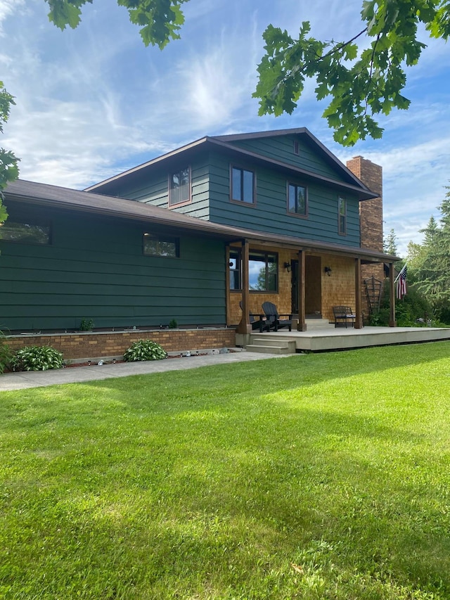 rear view of property featuring a lawn