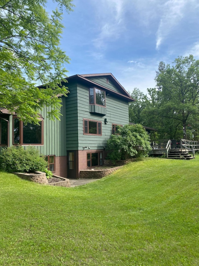 rear view of property with a yard and a wooden deck