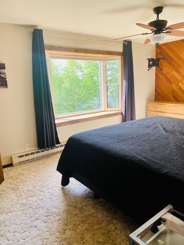 carpeted bedroom with wooden walls and baseboard heating