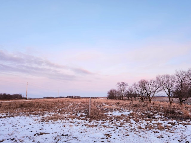 yard layered in snow with a rural view