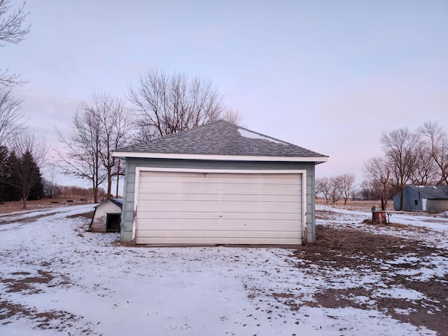 snow covered garage featuring a garage