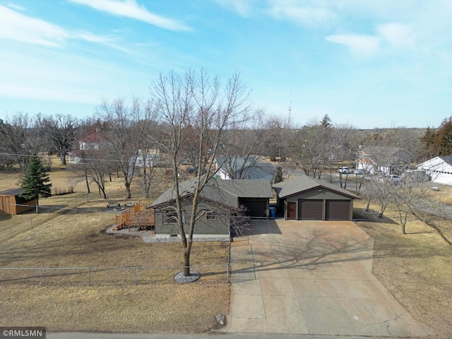 view of front of property featuring driveway, a garage, and a fenced front yard