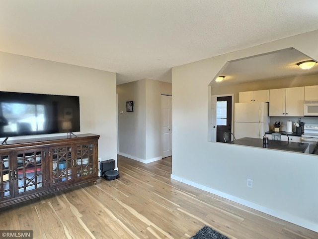 living area with light wood-style flooring and baseboards