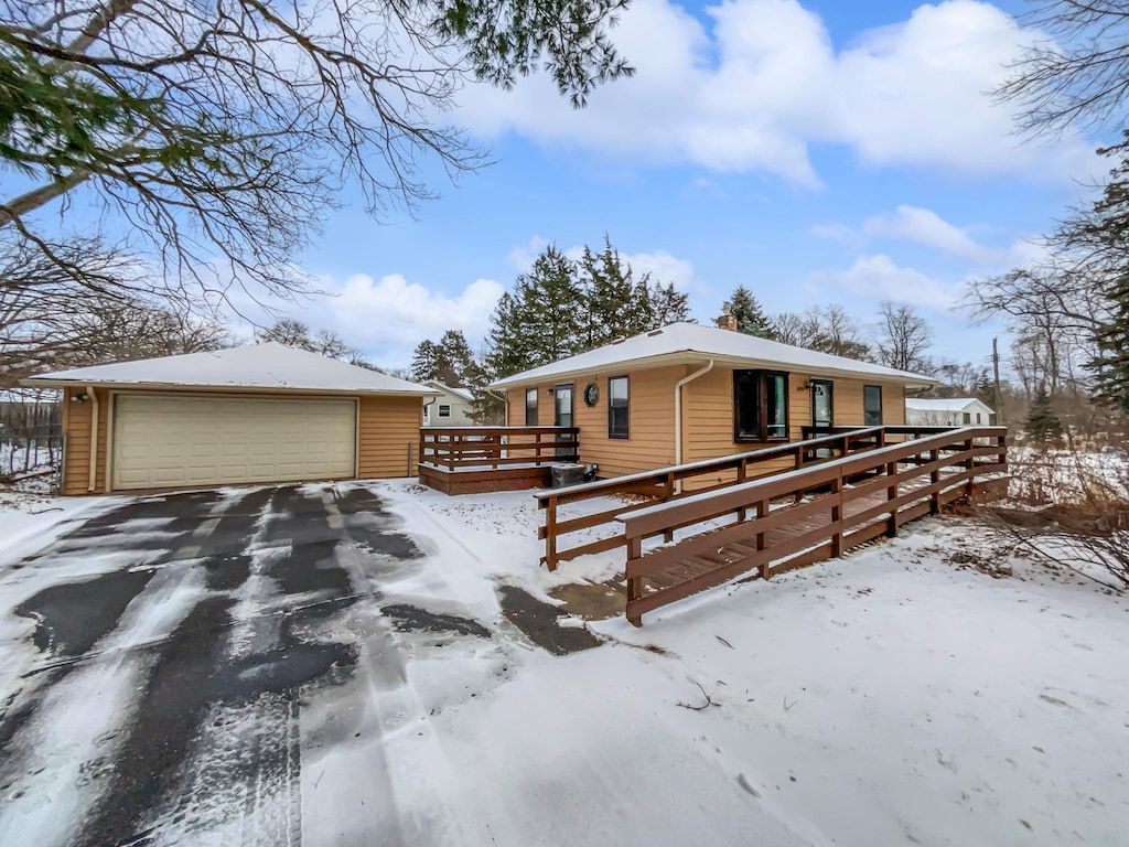 view of front of house featuring a garage, an outdoor structure, and a wooden deck