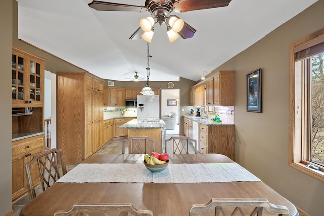 dining area with ceiling fan and vaulted ceiling