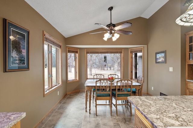 dining area with lofted ceiling, ceiling fan, baseboards, and a healthy amount of sunlight