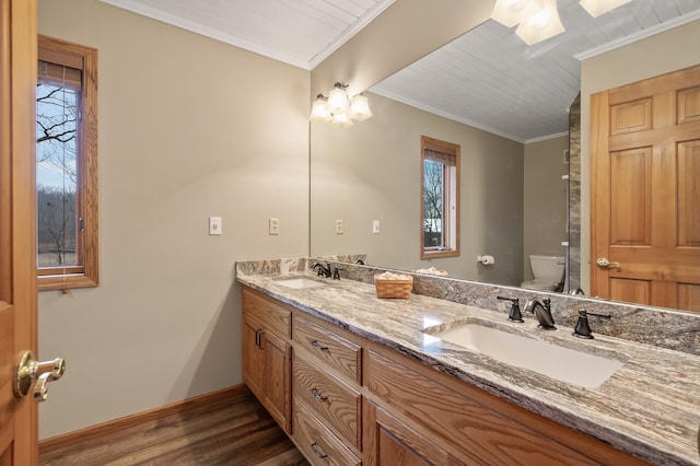 bathroom featuring a sink, toilet, and crown molding