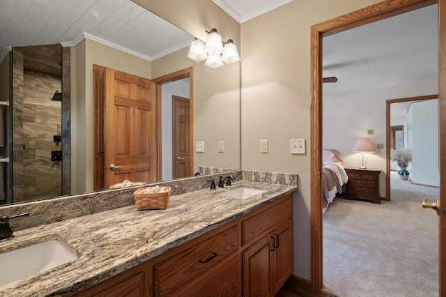 full bath with double vanity, crown molding, and a sink