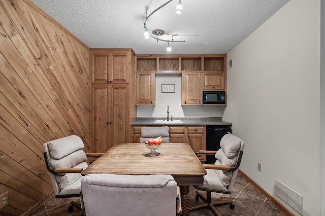 dining area with baseboards, wooden walls, visible vents, and a textured ceiling