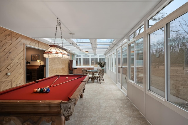 rec room with a skylight, billiards, wooden walls, and tile patterned floors