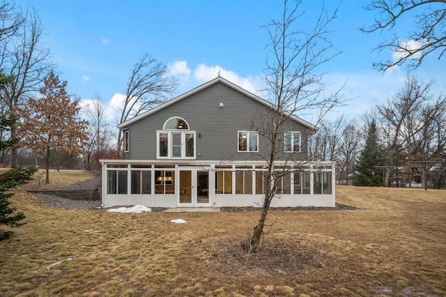 rear view of property with a yard and a sunroom