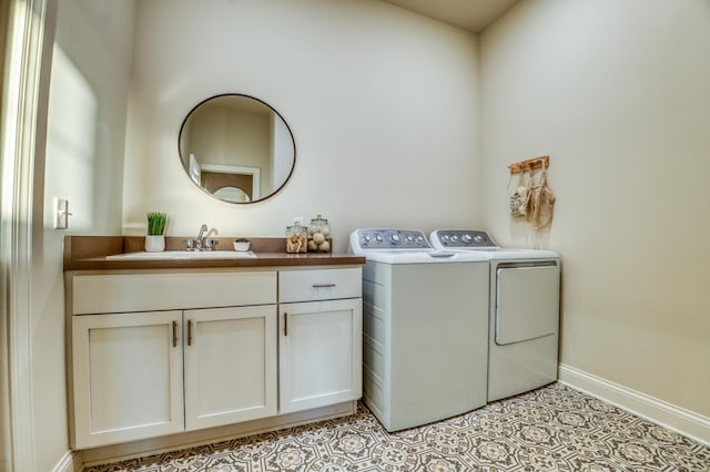 laundry area featuring cabinets, washer and clothes dryer, and sink