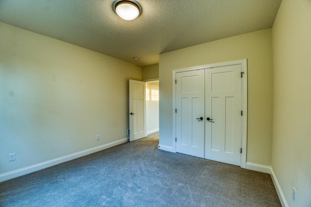 unfurnished bedroom featuring carpet floors, a textured ceiling, and a closet