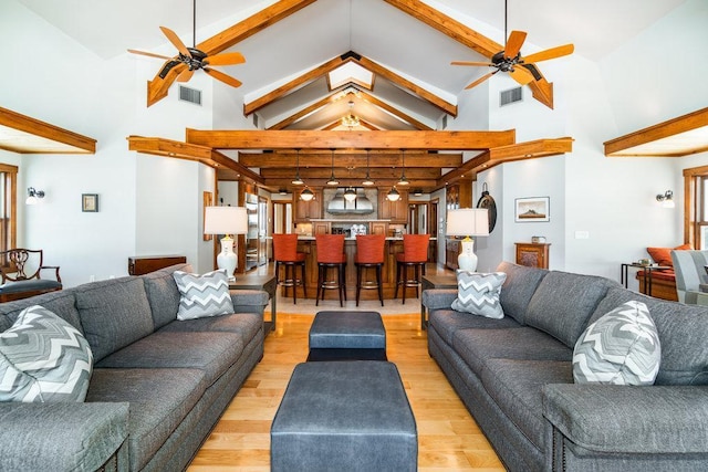 living room featuring light wood-style floors, visible vents, and a ceiling fan