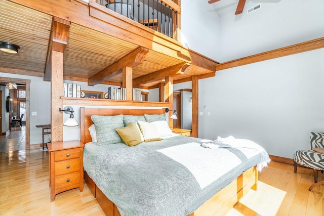 bedroom featuring baseboards, visible vents, wood ceiling, beamed ceiling, and light wood-style floors