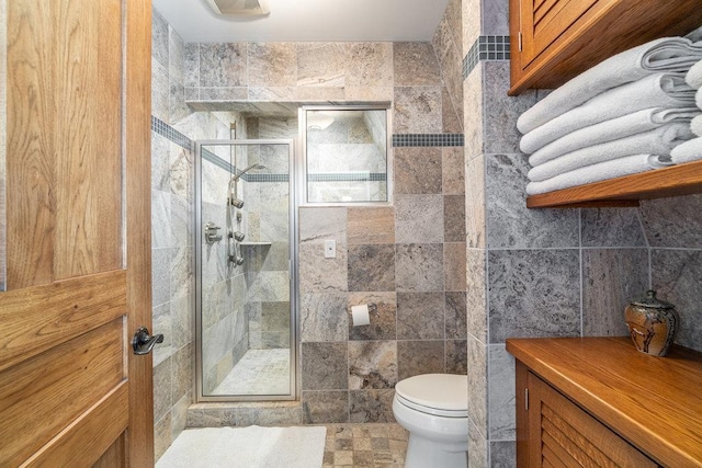 full bath featuring a stall shower, tile walls, and toilet