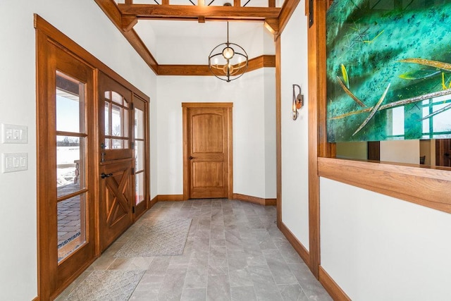 foyer featuring a chandelier and baseboards