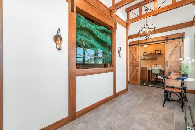 corridor with baseboards and a barn door