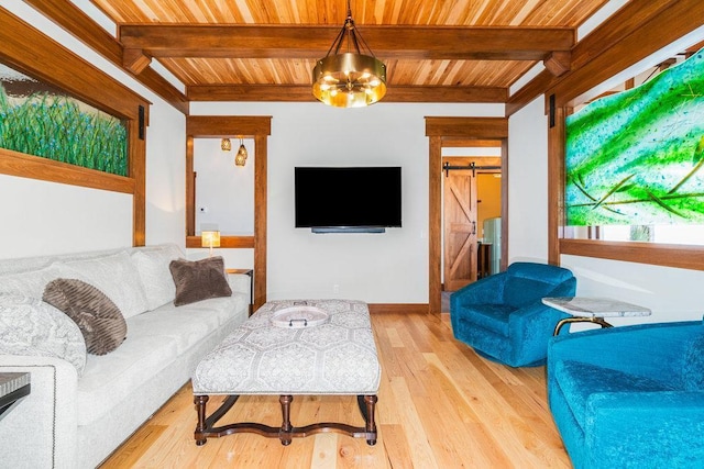 living room with light wood-style floors, a barn door, a chandelier, and beamed ceiling