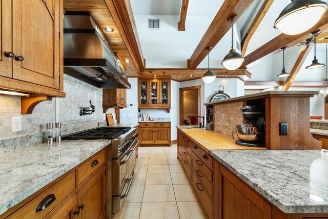 N7900 County Road J, Sherman Twp, WI 54751 - kitchen featuring range with two ovens, ventilation hood, brown cabinetry, tasteful backsplash, and light tile patterned floors