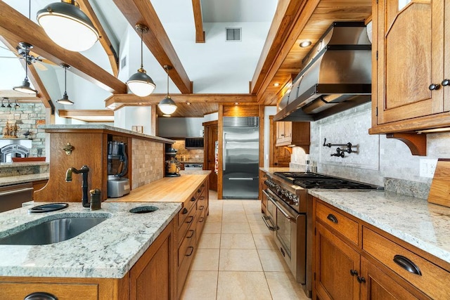N7900 County Road J, Sherman Twp, WI 54751 - kitchen featuring premium appliances, extractor fan, backsplash, brown cabinetry, and beam ceiling