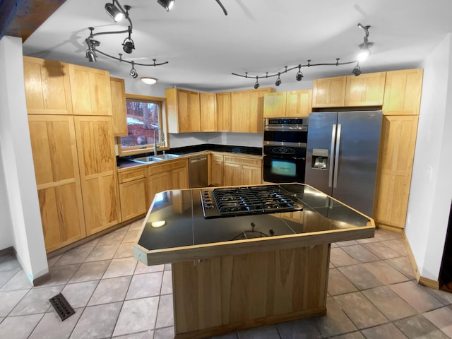 kitchen with stainless steel appliances, a center island, sink, light tile patterned floors, and light brown cabinets