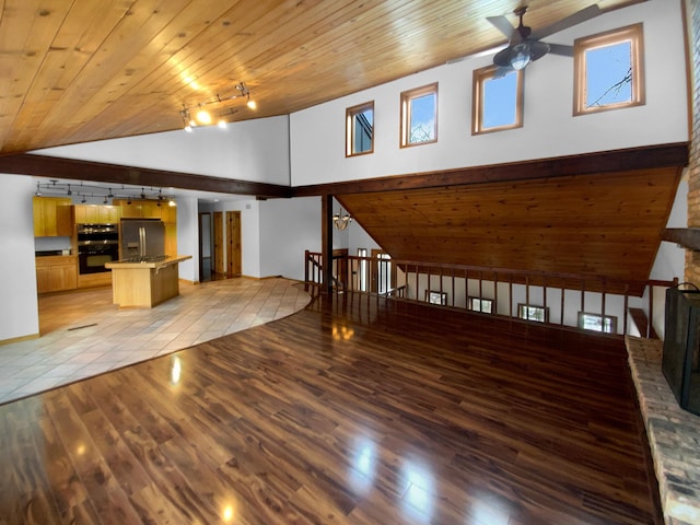 unfurnished living room featuring light hardwood / wood-style flooring, track lighting, ceiling fan, a large fireplace, and wooden ceiling