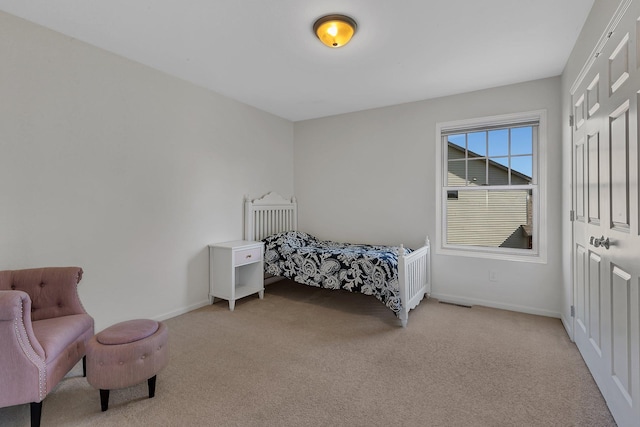 bedroom featuring light carpet, a closet, and baseboards