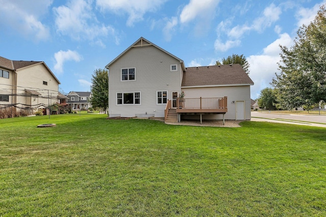 rear view of house featuring a deck, roof with shingles, and a lawn