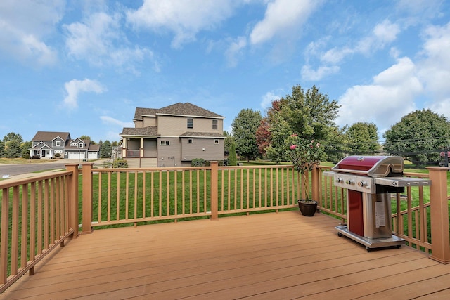 wooden deck with a residential view, a yard, and area for grilling