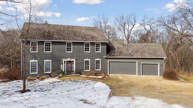 colonial home with an attached garage and driveway