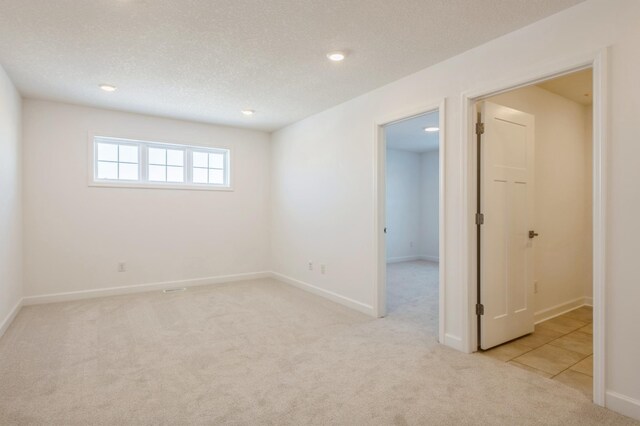 carpeted spare room with a textured ceiling