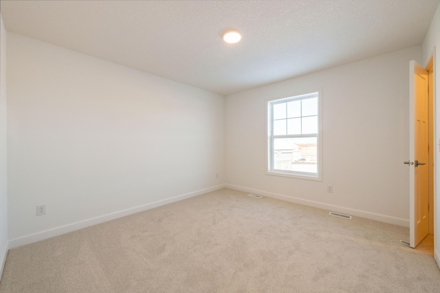 carpeted empty room with a textured ceiling