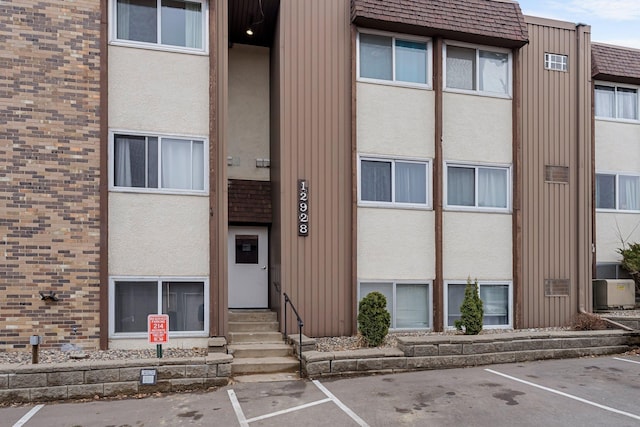 view of property featuring uncovered parking and entry steps