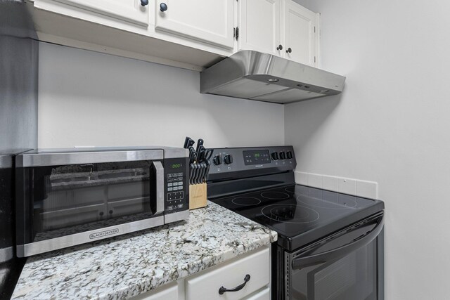 kitchen featuring a toaster, white cabinets, light stone counters, black range with electric stovetop, and under cabinet range hood