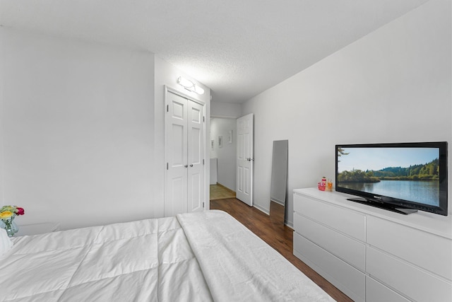 bedroom featuring a textured ceiling and dark wood-type flooring