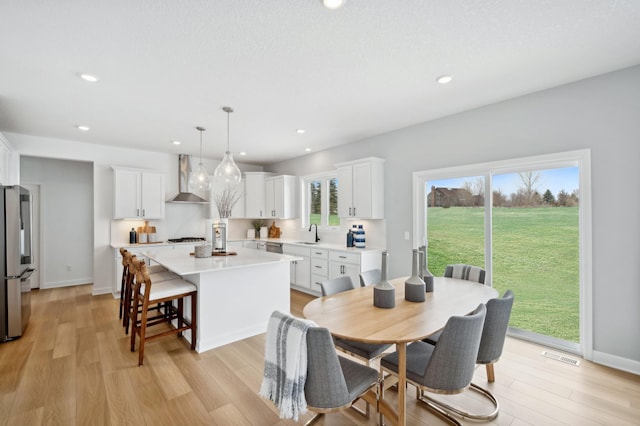 dining space featuring light wood-style flooring, visible vents, baseboards, and recessed lighting