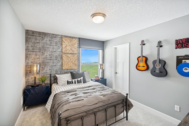 carpeted bedroom with an accent wall, baseboards, and a textured ceiling