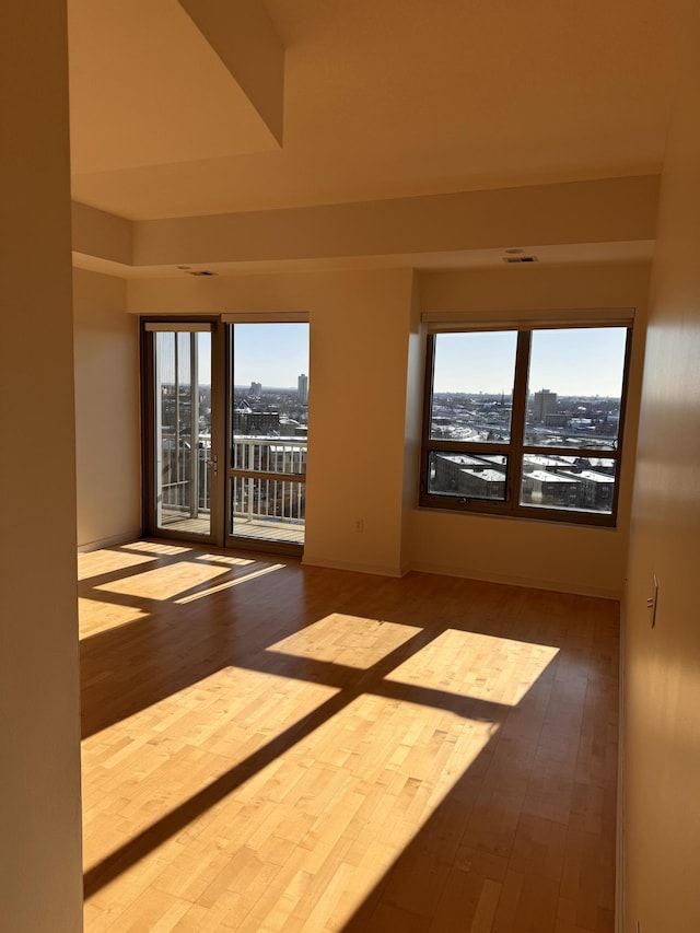 empty room featuring a view of city and wood finished floors